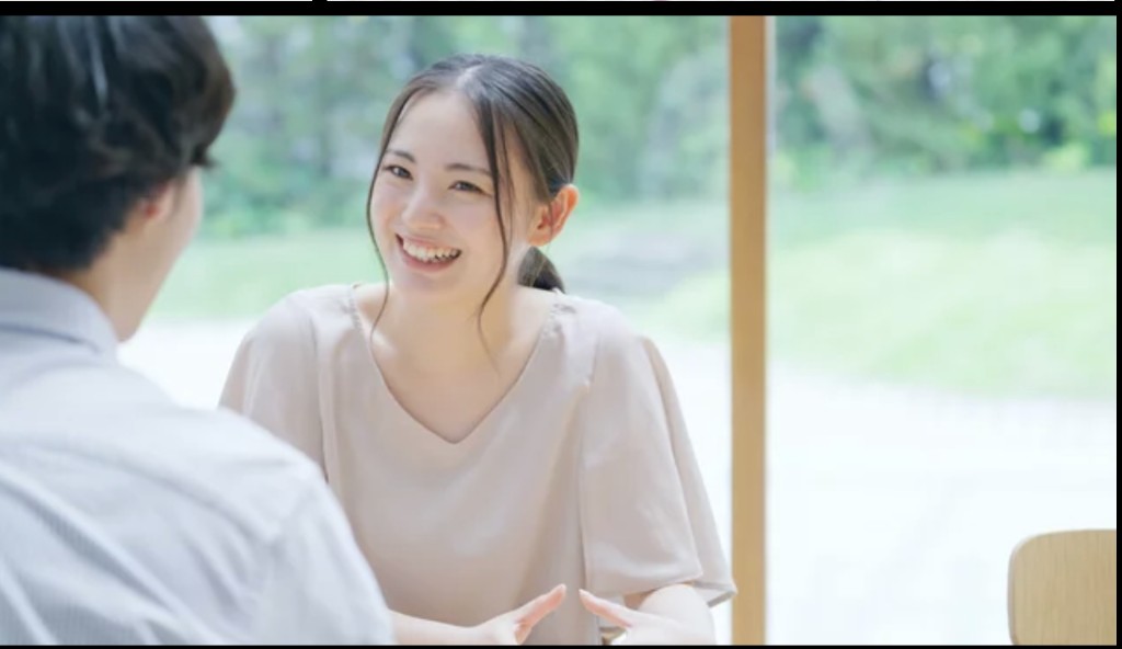 明るい室内で、カウンセラーが相談者の話を微笑みながら聞いている様子